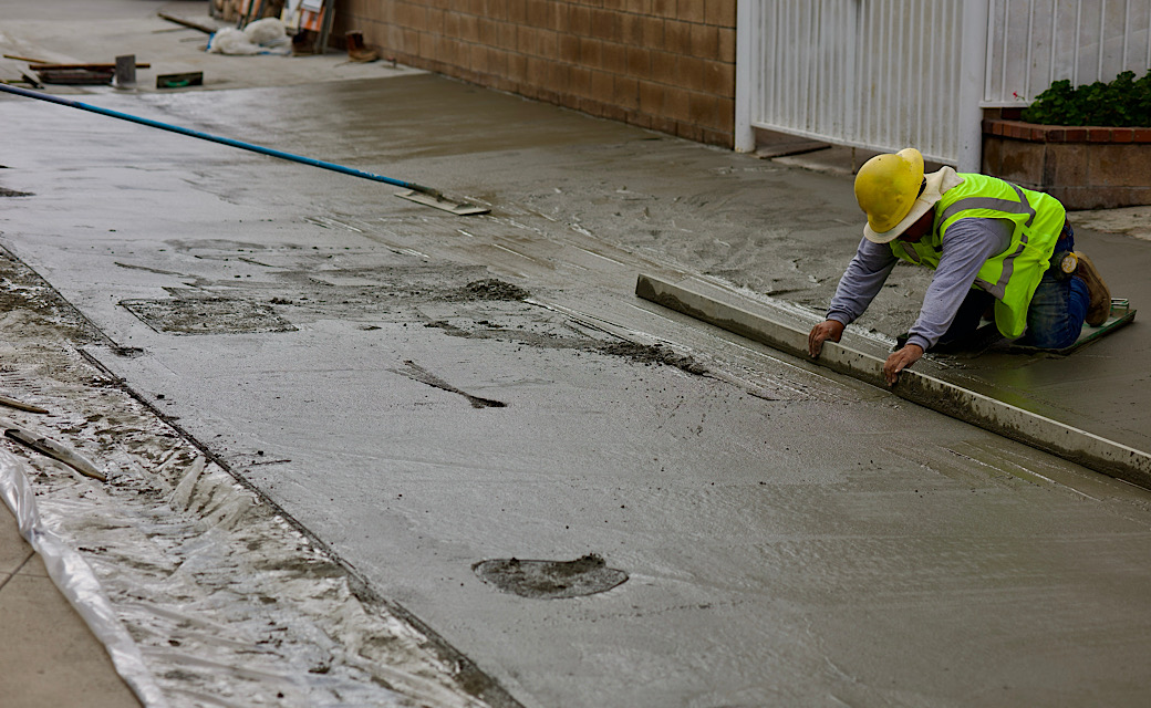 concrete worker spreading the wet material